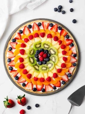 Assembled fruit pizza on counter.
