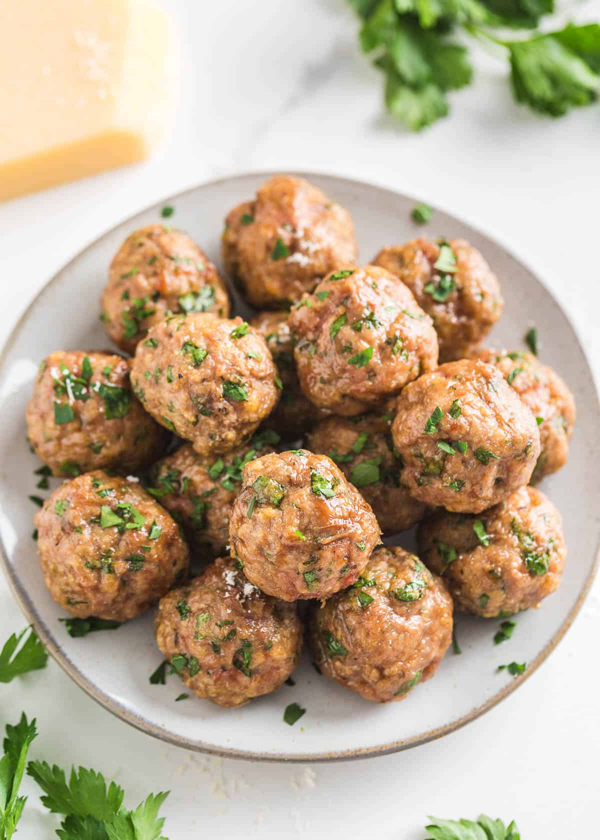 These turkey meatballs are just as comforting as beef but leaner with ground turkey! They are moist and flavorful with a combination of fresh and dried herbs plus Parmesan. Turkey meatballs on a plate.