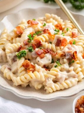 Chicken bacon ranch pasta on a white plate with gold fork.